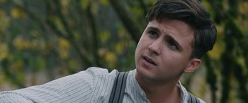 Movie still from “1922” (2017), directed by Zak Hilditch – A young man with suspenders looks up into the sky; Close Up shot, Over the shoulder angle