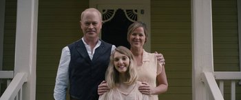 Movie still from “1922” (2017), directed by Zak Hilditch – A man , woman , and a young girl pose for a picture; Medium shot, Low angle