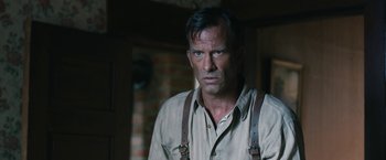 Movie still from “1922” (2017), directed by Zak Hilditch – A person wearing suspenders; Close Up shot, Over the shoulder angle