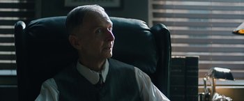 Movie still from “1922” (2017), directed by Zak Hilditch – An older man sitting in an office chair; Close Up shot, Over the shoulder angle