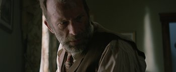 Movie still from “1922” (2017), directed by Zak Hilditch – An older man wearing a suit and a tie; Close Up shot, Over the shoulder angle