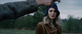 Movie still from “1922” (2017), directed by Zak Hilditch – A woman in a brown coat and a blue head scarf; Close Up shot, Over the shoulder angle