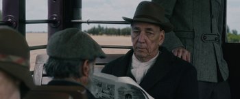 Movie still from “1922” (2017), directed by Zak Hilditch – A man wearing a hat sitting next to another man; Close Up shot, Over the shoulder angle