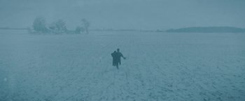 Movie still from “1922” (2017), directed by Zak Hilditch – A man walking across a snow covered field; Extreme Wide shot, High angle