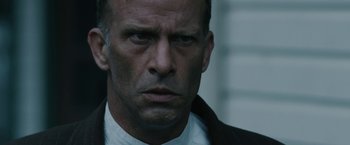 Movie still from “1922” (2017), directed by Zak Hilditch – A person wearing a suit and tie; Close Up shot, Low angle