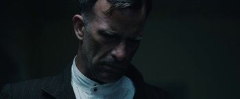 Movie still from “1922” (2017), directed by Zak Hilditch – A person wearing a suit and tie; Close Up shot, Low angle