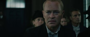 Movie still from “1922” (2017), directed by Zak Hilditch – A man in a suit and tie looking at the camera; Close Up shot, Over the shoulder angle