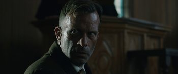 Movie still from “1922” (2017), directed by Zak Hilditch – A person wearing a suit and tie; Close Up shot, Over the shoulder angle