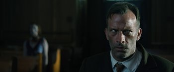 Movie still from “1922” (2017), directed by Zak Hilditch – A person wearing a suit and tie; Close Up shot, Over the shoulder angle