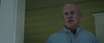 Movie still from “1922” (2017), directed by Zak Hilditch – An older man with white hair wearing a blue striped shirt; Close Up shot, Low angle