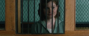 Movie still from “1922” (2017), directed by Zak Hilditch – A young woman behind bars looking at the camera; Close Up shot, Over the shoulder angle