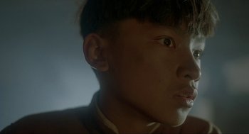 Movie still from “Shanghai Triad” (1995), directed by Yimou Zhang – A young man's face in the dark; Close Up shot, Low angle