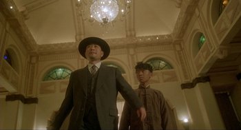 Movie still from “Shanghai Triad” (1995), directed by Yimou Zhang – A man in a suit and a man in a hat; Medium shot, Low angle