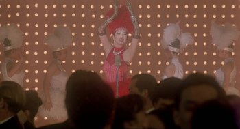 Movie still from “Shanghai Triad” (1995), directed by Yimou Zhang – A group of people in a room with a microphone; Medium shot, Low angle