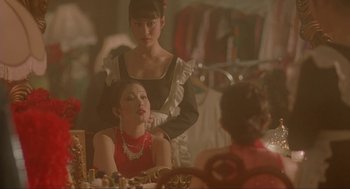 Movie still from “Shanghai Triad” (1995), directed by Yimou Zhang – Two women sitting at a table in front of a mirror; Medium shot, Over the shoulder angle