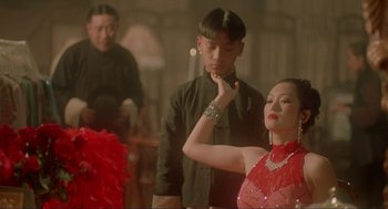 Movie still from “Shanghai Triad” (1995), directed by Yimou Zhang – A man and a woman in a red dress; Medium shot, Over the shoulder angle