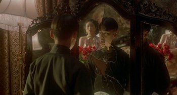 Movie still from “Shanghai Triad” (1995), directed by Yimou Zhang – A man and a woman looking in a mirror; Close Up shot, Over the shoulder angle