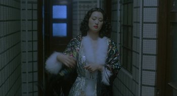 Movie still from “Shanghai Triad” (1995), directed by Yimou Zhang – A woman in a long dress holding a bottle of wine; Medium shot, High angle