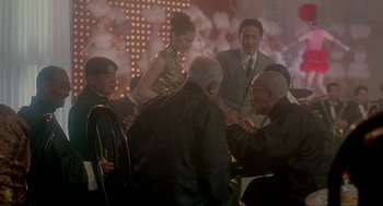 Movie still from “Shanghai Triad” (1995), directed by Yimou Zhang – A group of people sitting around a room; Medium shot, Over the shoulder angle