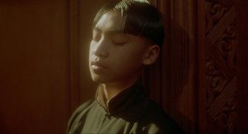 Movie still from “Shanghai Triad” (1995), directed by Yimou Zhang – A young man with his eyes closed with his head tilted to the side; Close Up shot, High angle