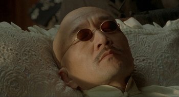 Movie still from “Shanghai Triad” (1995), directed by Yimou Zhang – An old man with a bald head wearing sunglasses; Close Up shot, High angle