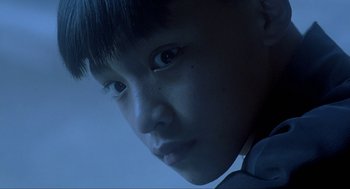 Movie still from “Shanghai Triad” (1995), directed by Yimou Zhang – A young boy is looking into the camera; Close Up shot, Low angle