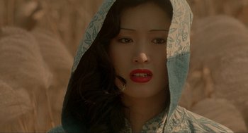 Movie still from “Shanghai Triad” (1995), directed by Yimou Zhang – A woman with red lipstick wearing a blue and white hooded shirt; Close Up shot, High angle