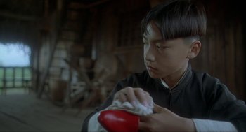 Movie still from “Shanghai Triad” (1995), directed by Yimou Zhang – A young man is cleaning his hands with a cloth; Close Up shot, Low angle