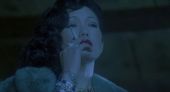 Movie still from “Shanghai Triad” (1995), directed by Yimou Zhang – A woman holding a cell phone up to her ear; Close Up shot, Over the shoulder angle