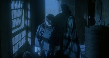 Movie still from “Shanghai Triad” (1995), directed by Yimou Zhang – Two people standing next to each other near a window; Medium shot, Over the shoulder angle