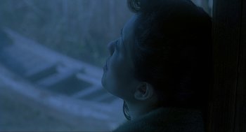 Movie still from “Shanghai Triad” (1995), directed by Yimou Zhang – A person looking out a window; Close Up shot, Over the shoulder angle