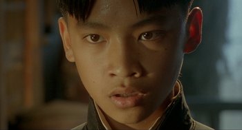 Movie still from “Shanghai Triad” (1995), directed by Yimou Zhang – A young asian man's face; Close Up shot, High angle