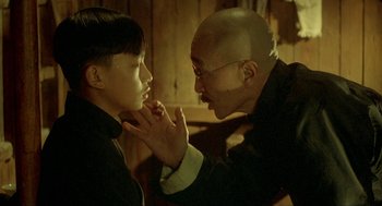 Movie still from “Shanghai Triad” (1995), directed by Yimou Zhang – An older man touching a young boy's face; Close Up shot, Over the shoulder angle
