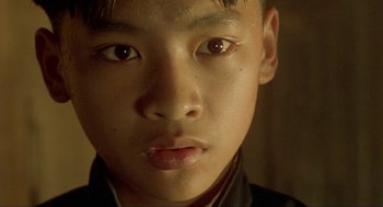 Movie still from “Shanghai Triad” (1995), directed by Yimou Zhang – A young boy's face with brown eyes; Close Up shot, High angle