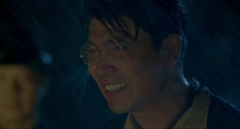Movie still from “Shanghai Triad” (1995), directed by Yimou Zhang – A person wearing glasses and smiling; Close Up shot, Low angle