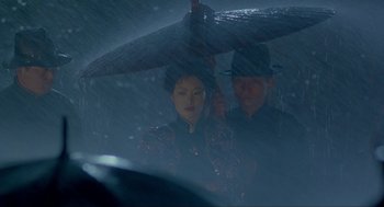Movie still from “Shanghai Triad” (1995), directed by Yimou Zhang – A man and a woman under an umbrella in the rain; Medium shot, Over the shoulder angle