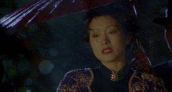 Movie still from “Shanghai Triad” (1995), directed by Yimou Zhang – A person holding an open umbrella; Close Up shot, Over the shoulder angle