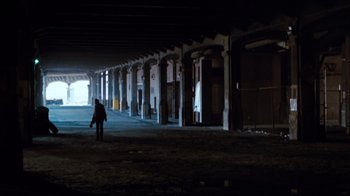 Movie still from “Sharky's Machine” (1981), directed by Burt Reynolds – A person is walking in a parking lot at night; Extreme Wide shot, High angle