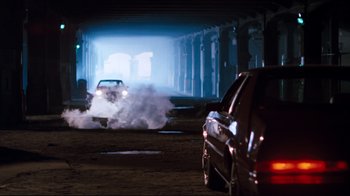 Movie still from “Sharky's Machine” (1981), directed by Burt Reynolds – Two cars are driving down the street in a tunnel; Wide shot, High angle