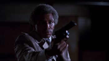 Movie still from “Sharky's Machine” (1981), directed by Burt Reynolds – A man holding a gun while wearing a suit and tie; Close Up shot, Low angle