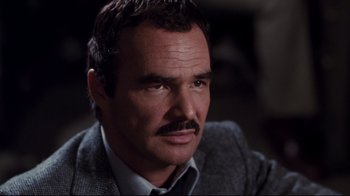 Movie still from “Sharky's Machine” (1981), directed by Burt Reynolds – A person wearing a suit and tie; Close Up shot, Low angle