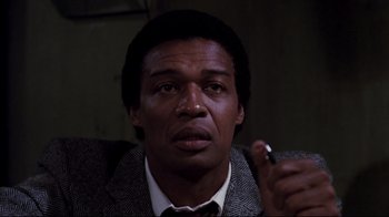 Movie still from “Sharky's Machine” (1981), directed by Burt Reynolds – A person wearing a suit and tie; Close Up shot, Low angle