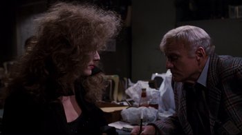 Movie still from “Sharky's Machine” (1981), directed by Burt Reynolds – An older man and a young woman are sitting at a table; Medium shot, Over the shoulder angle