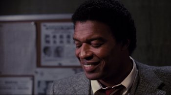 Movie still from “Sharky's Machine” (1981), directed by Burt Reynolds – A person wearing a suit and tie; Close Up shot, Over the shoulder angle