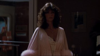 Movie still from “Sharky's Machine” (1981), directed by Burt Reynolds – A woman in a white dress and pink robe; Medium shot, Low angle