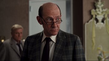 Movie still from “Sharky's Machine” (1981), directed by Burt Reynolds – An older man wearing a suit and tie; Close Up shot, Over the shoulder angle