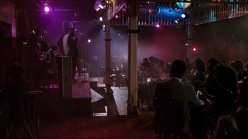 Movie still from “Sharky's Machine” (1981), directed by Burt Reynolds – People are sitting in a room with a microphone; Extreme Wide shot, Over the shoulder angle