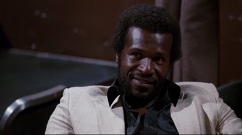 Movie still from “Sharky's Machine” (1981), directed by Burt Reynolds – A person wearing a suit and tie; Close Up shot, Low angle