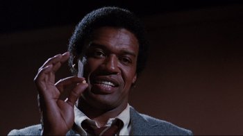 Movie still from “Sharky's Machine” (1981), directed by Burt Reynolds – A person holding something in his hand; Close Up shot, Low angle