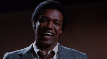 Movie still from “Sharky's Machine” (1981), directed by Burt Reynolds – A person wearing a suit and tie; Close Up shot, Low angle